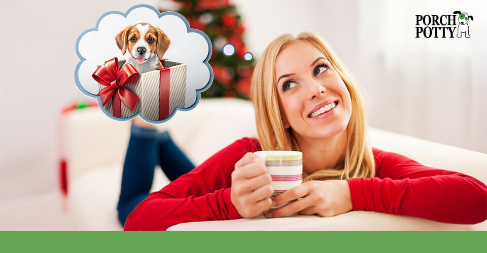 Woman smiling and holding a coffee cup, thinking about a puppy as a Christmas gift