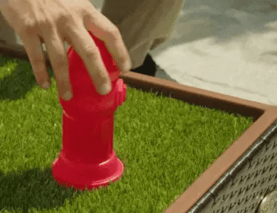 Red potty-training hydrant on a Porch Potty grass surface